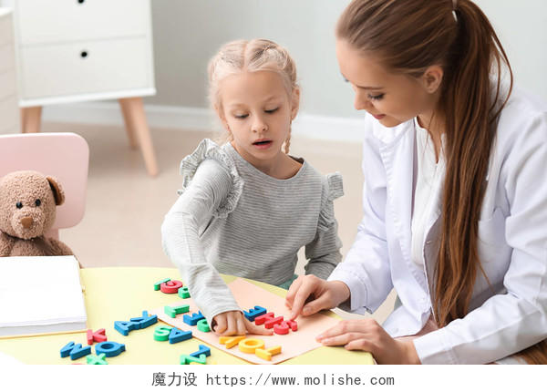 小女孩与言语治疗师在房间撰写字母词